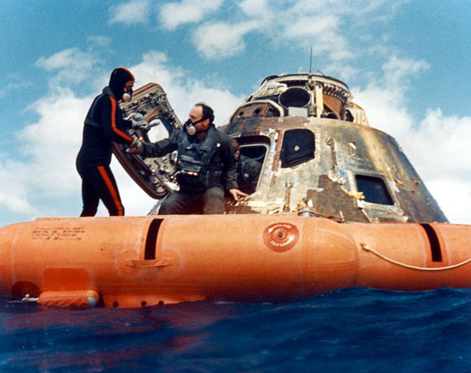 A US Navy diver helps Mitchell out of the space capsule.