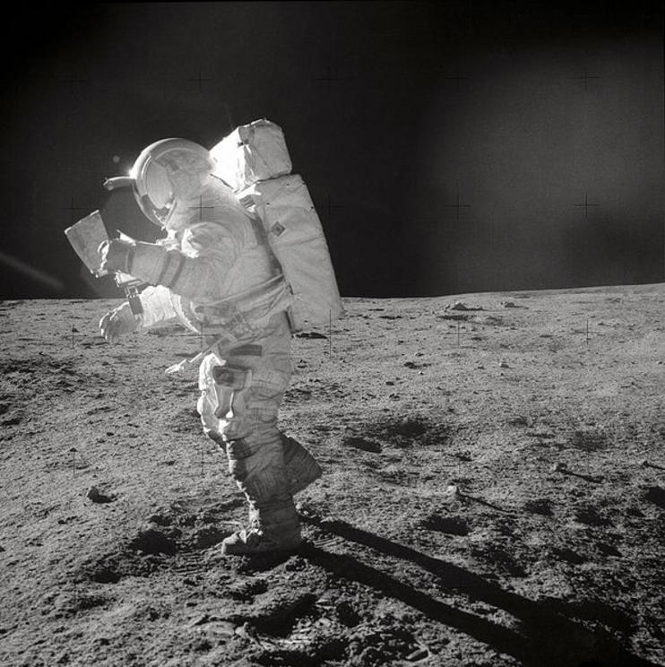 Edgar Mitchell studies a map while walking on the Moon.