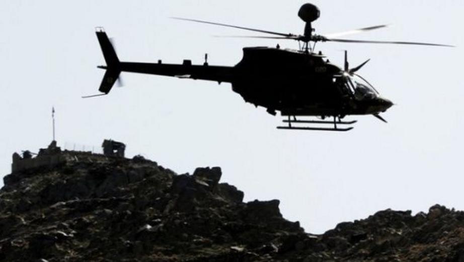 A U.S. military's Kiowa attack helicopter flies past an Afghan military combat outpost in Kunar province, eastern Afghanistan, on March 14, 2012. | Photo: Reuters