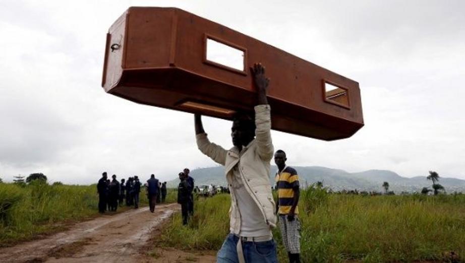A man carries an empty coffin at the Paloko cemetery in Waterloo, Sierra Leone. | Photo: Reuters