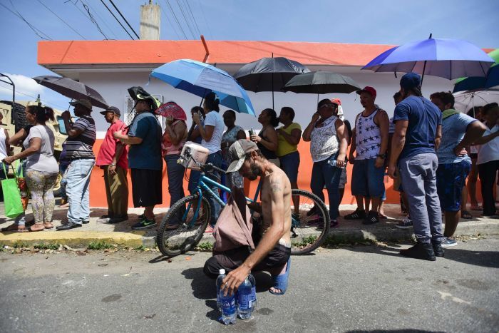 People affected by Hurricane Maria wait in line at Barrio Obrero to receive supplies from the National Guard, in San Juan, Puerto Rico