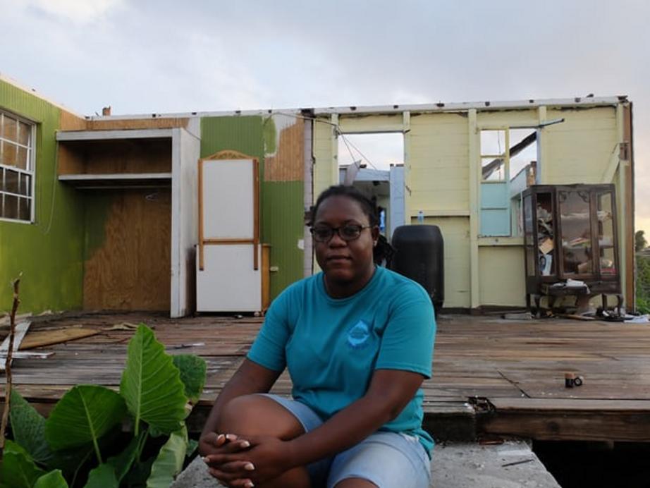 Knacynthar Nedd, leader of the Barbuda council, sits on the doorstep of a house that lost two walls and its roof.