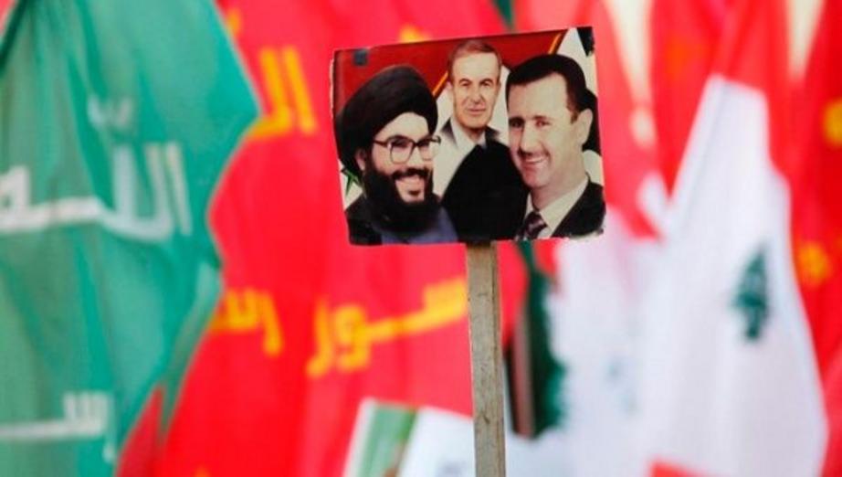 Supporters wave pictures of Hezbollah leader Nasrallah, Syria's late President Hafez al-Assad, and current Syrian President Bashar al-Assad. | Photo: Reuters
