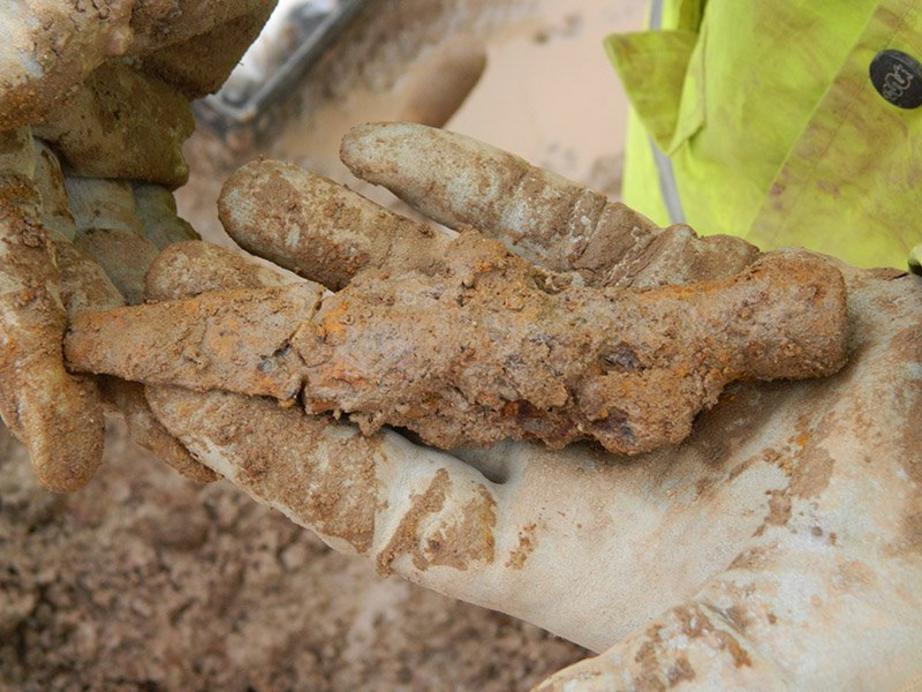 An iron spearhead just after it was discovered