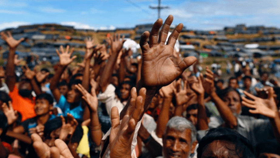 Rohingya refugees stretch their hands to receive aid distributed by local organisations at Balukhali makeshift refugee camp in Cox's Bazar, Bangladesh. | Photo: Reuters 