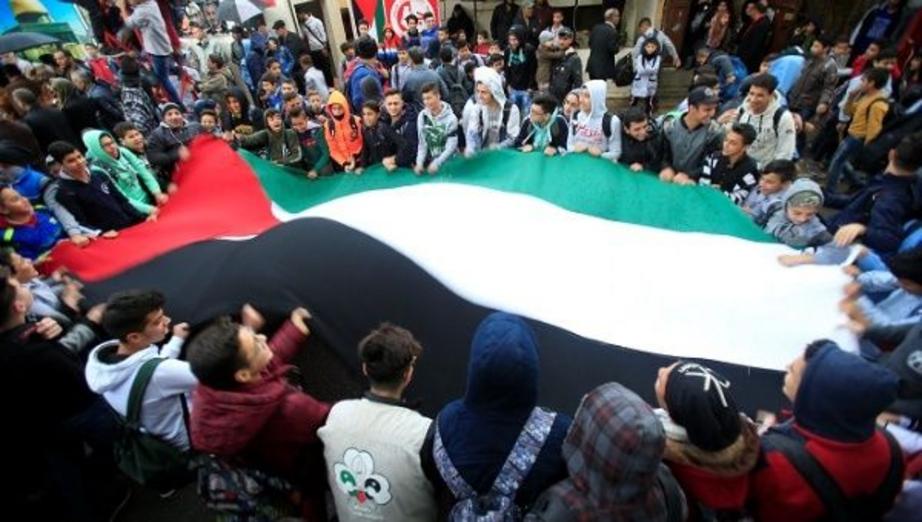 Students hold a Palestinian flag inside the Ain el-Hilweh refugee camp near Sidon, southern Lebanon, December 6, 2017. | Photo: Reuters