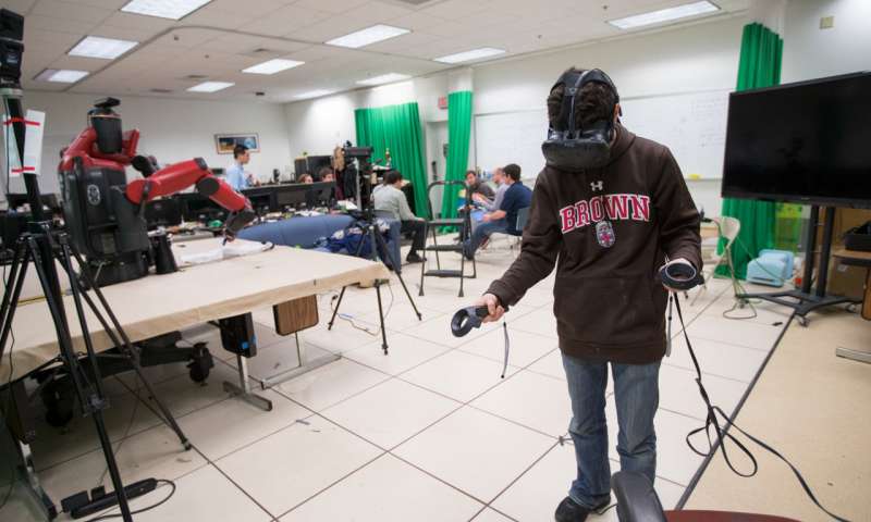 Brown University undergraduate Eric Rosen operates a Baxter robot using a virtual reality interface developed in Brown's Humans to Robots lab. Credit: Nick Dentamaro / Brown University 