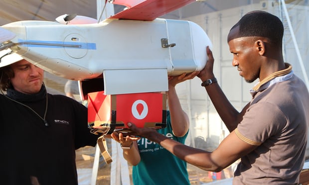  A technician from Zipline installs a cardboard box with a paper parachute in a drone in Muhanga, 50km west of Kigali. Photograph: Stephanie Aglietti/AFP/Getty Images 