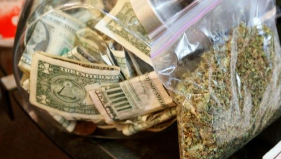 A bag of marijuana being prepared for sale sits next to a money jar at BotanaCare in Northglenn, Colorado, U.S., Dec. 31, 2013. | Photo: Reuters