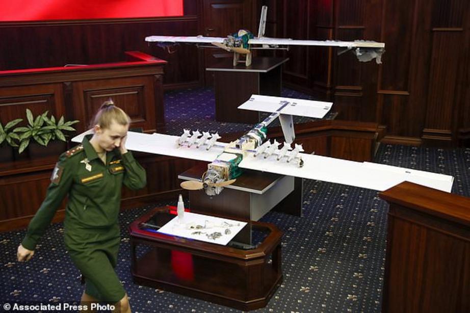 A Russian officer walks next to drones that allegedly attacked a Russian air base in Syria and were captured by the Russian military - the two drones were put on display at the Russian defence ministry in Moscow