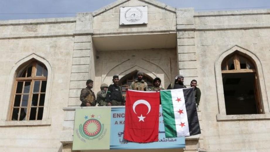 Members of Turkish forces and Free Syrian Army pose with their flags as they are deployed in Afrin, Syria March 18,2018. | Photo: Reuters