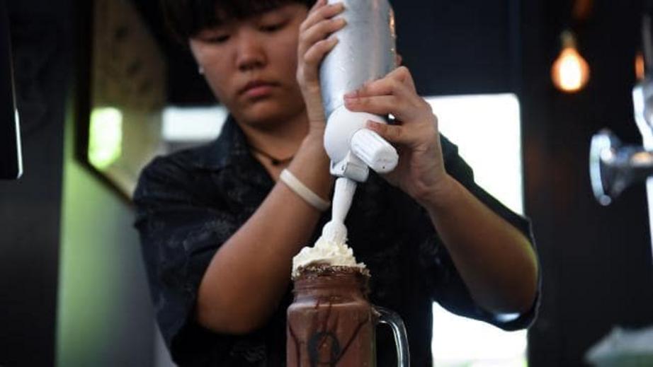 A barista prepares a chocolate milkshake called ‘Death’ at the Kid Mai Death Awareness Cafe.