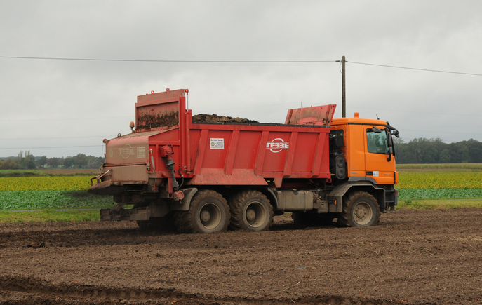 A vehicle spreads treated sewage sludge, aka “biosolids,” on a field for growing crops.